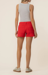 Person wearing red shorts and a gray tank top on a beige background