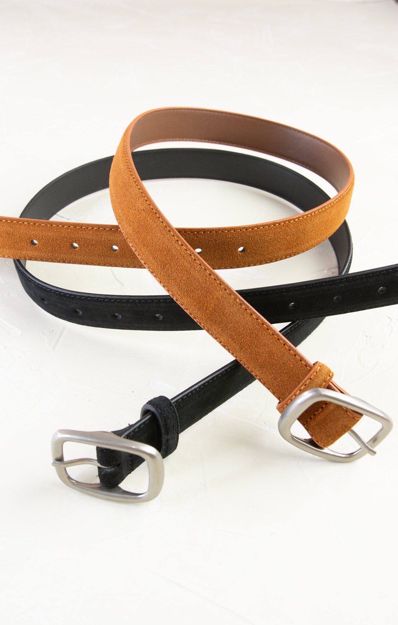Two belts, one black and one brown, with metal buckles on a white background.