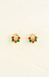 Gold hoop earrings with red and green gemstones on a beige background