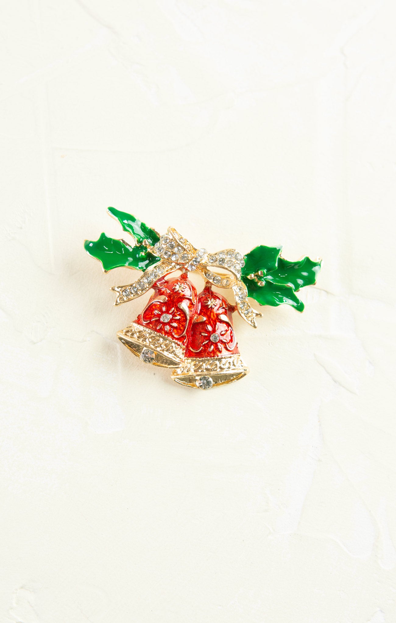 Decorative brooch with red berries and green leaves on a white background