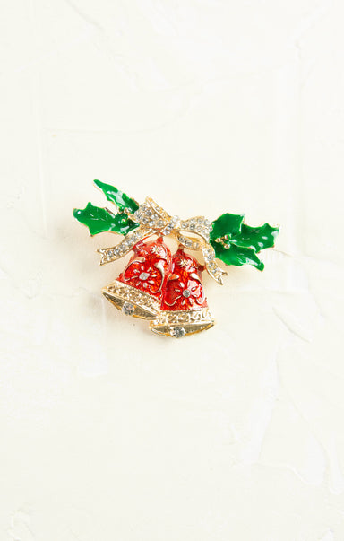 Decorative brooch with red berries and green leaves on a white background