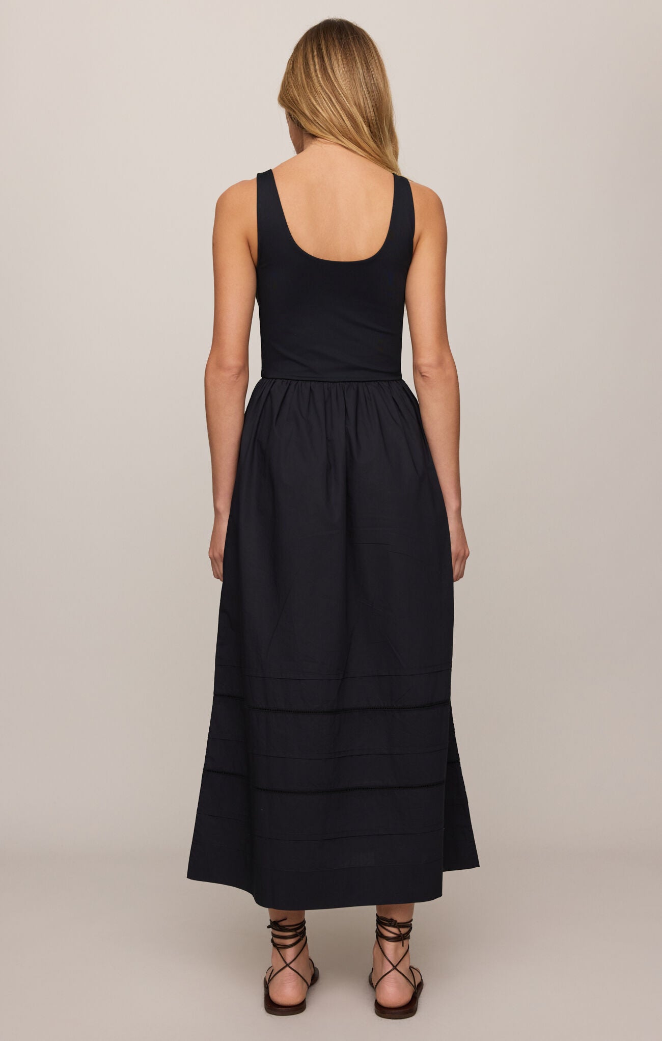 Black sleeveless dress worn by a person on a plain background