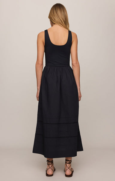 Black sleeveless dress worn by a person on a plain background