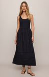 Woman wearing a black sleeveless dress against a plain background