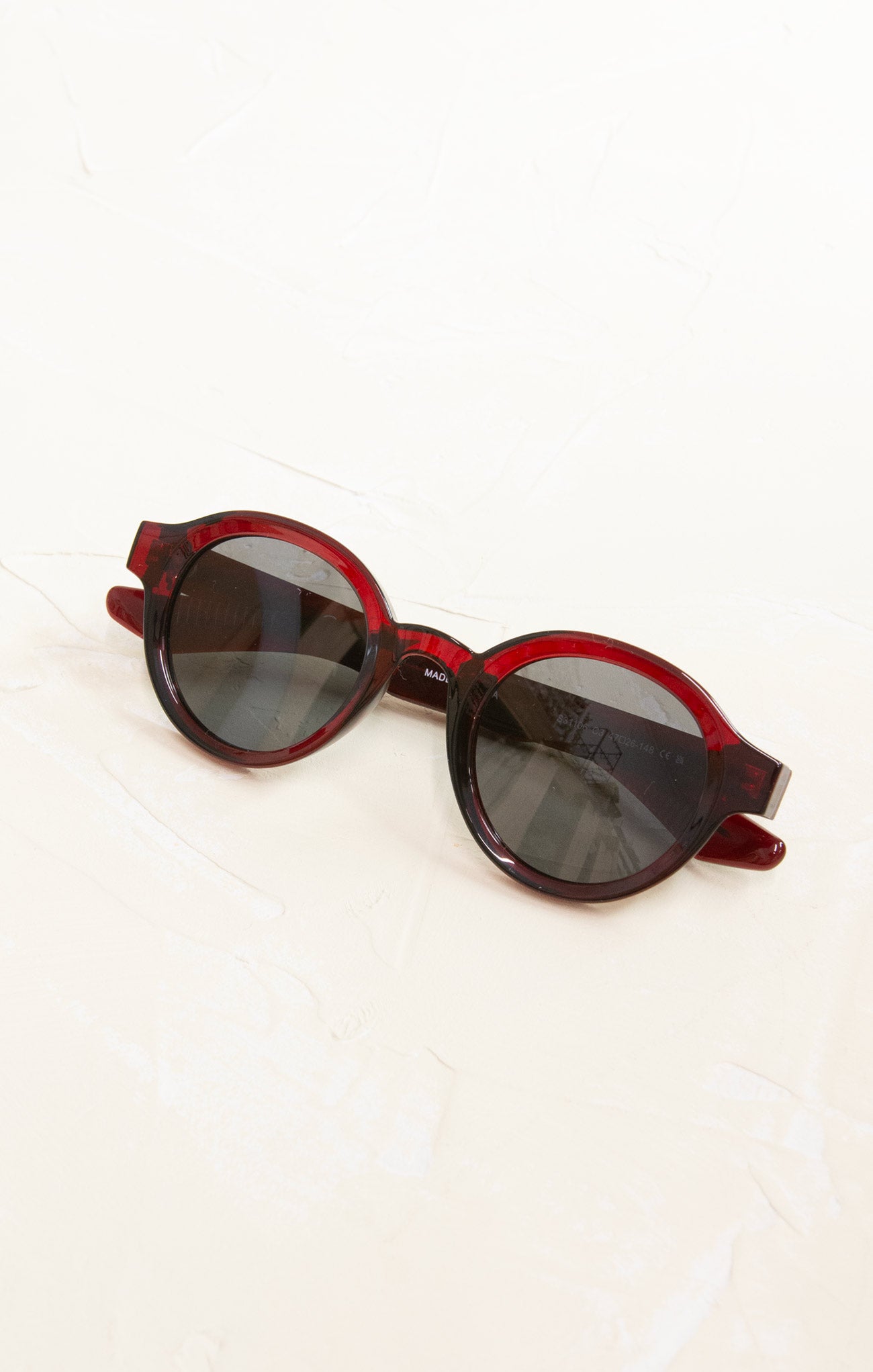 Red sunglasses with dark lenses on a white background