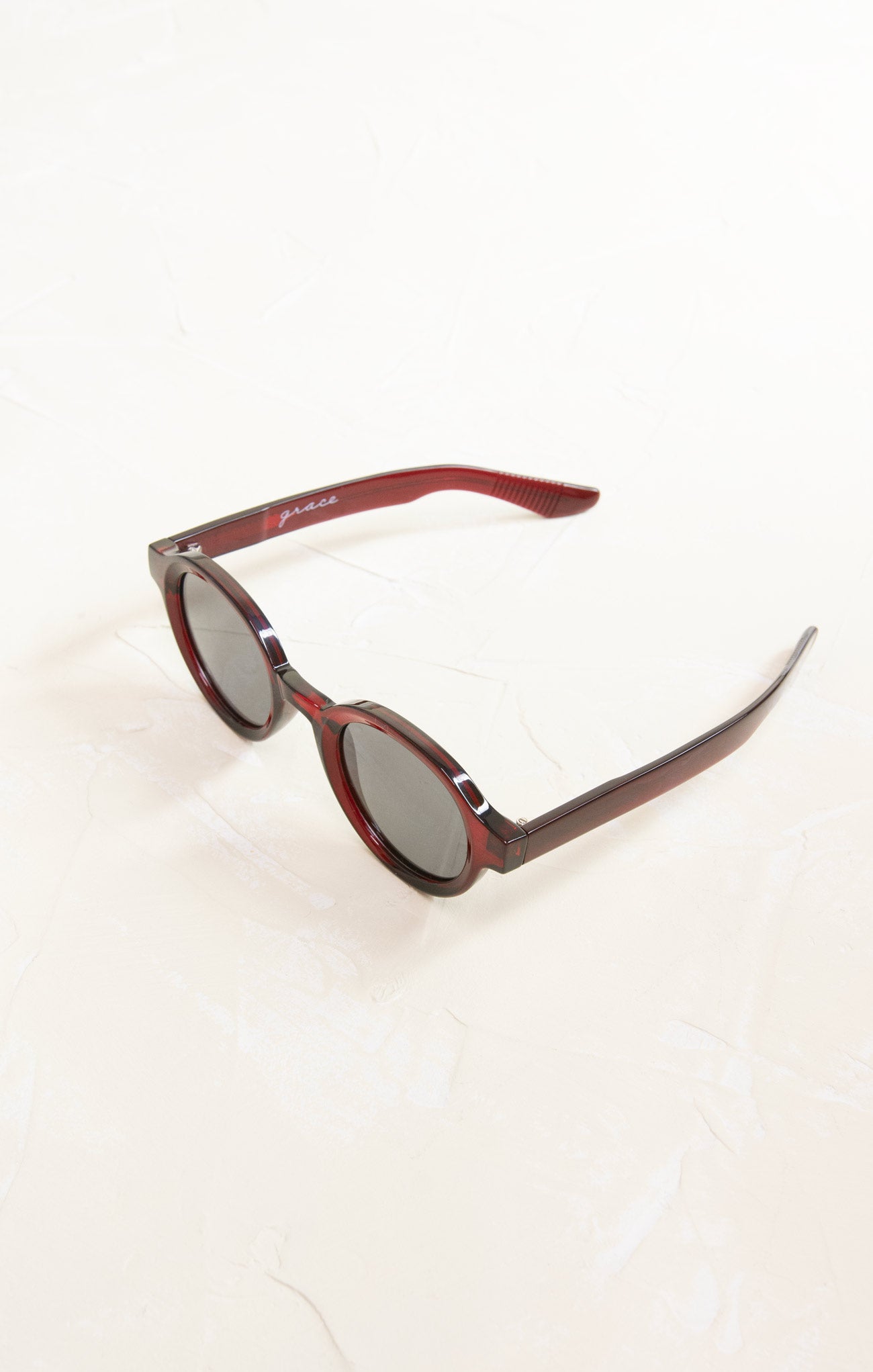 Sunglasses with red frame and dark lenses on a white background