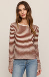 Woman wearing a striped long-sleeve top and jeans against a plain background