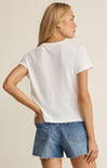 Woman wearing a white t-shirt and denim shorts on a beige background