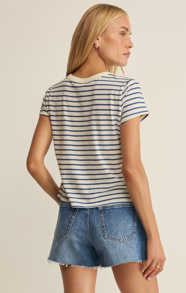 Woman wearing a striped shirt and denim shorts on a beige background