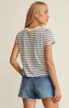Woman wearing a striped shirt and denim shorts on a beige background