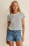 Woman wearing a striped shirt and denim shorts against a beige background
