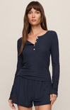 Woman wearing a navy blue long-sleeve top and shorts set on a beige background