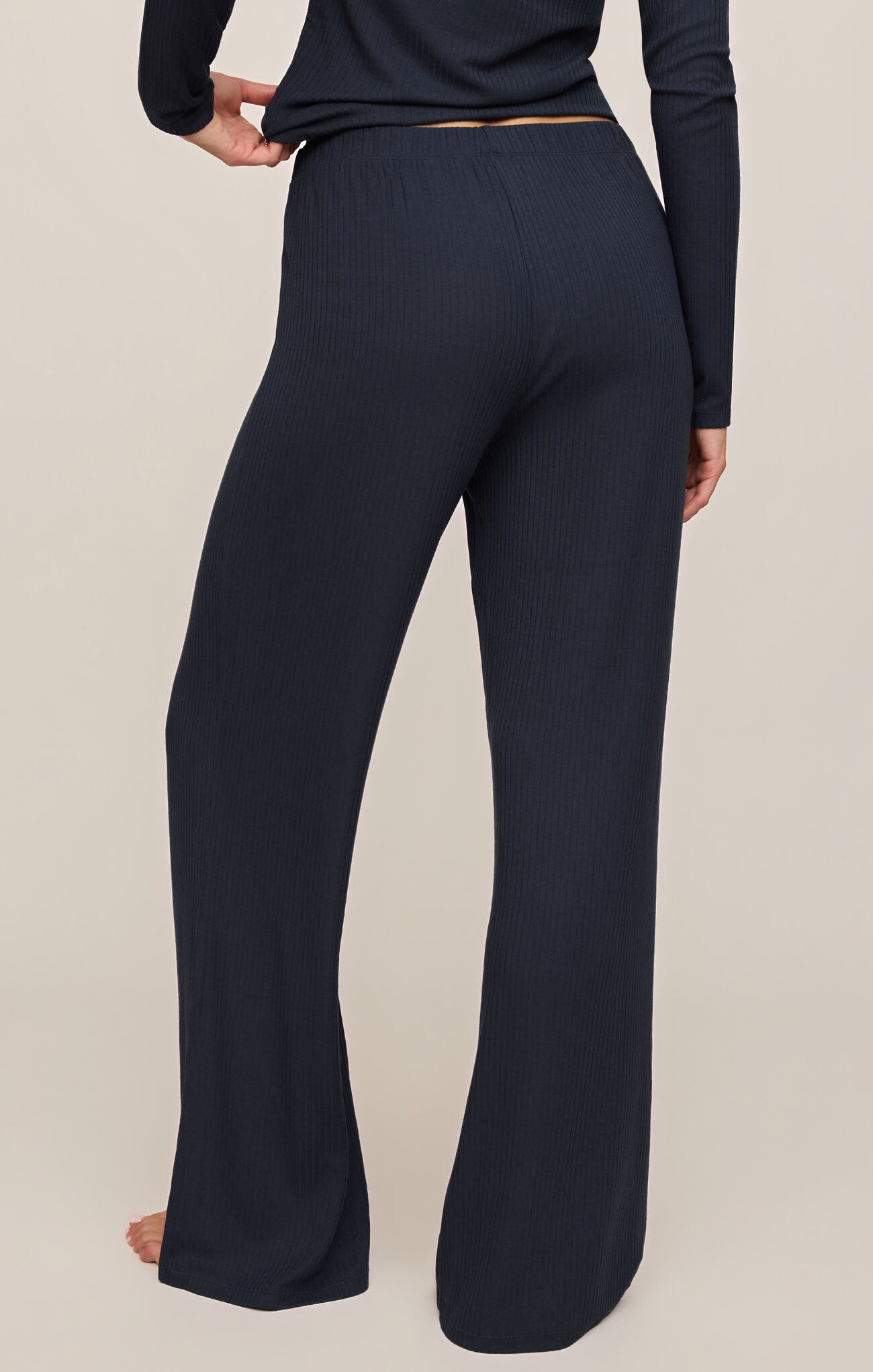 Navy blue pants worn by a person on a beige background