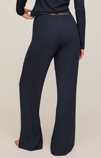 Navy blue pants worn by a person on a beige background