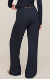 Navy blue pants worn by a person on a beige background