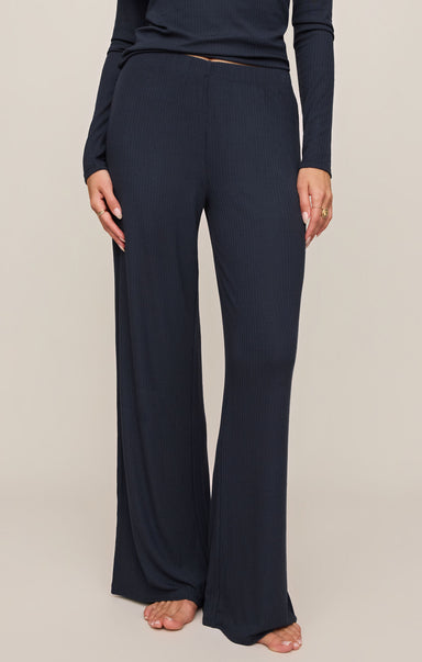 Navy blue pants worn by a person on a beige background