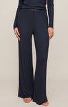 Navy blue pants worn by a person on a beige background