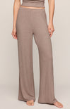 Person wearing brown ribbed pants on a plain background