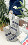 Knitted socks with a pattern in front of a Christmas tree