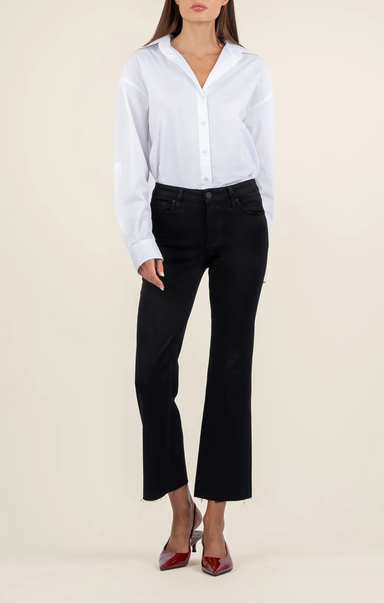 Person wearing a white button-up shirt and black pants on a beige background