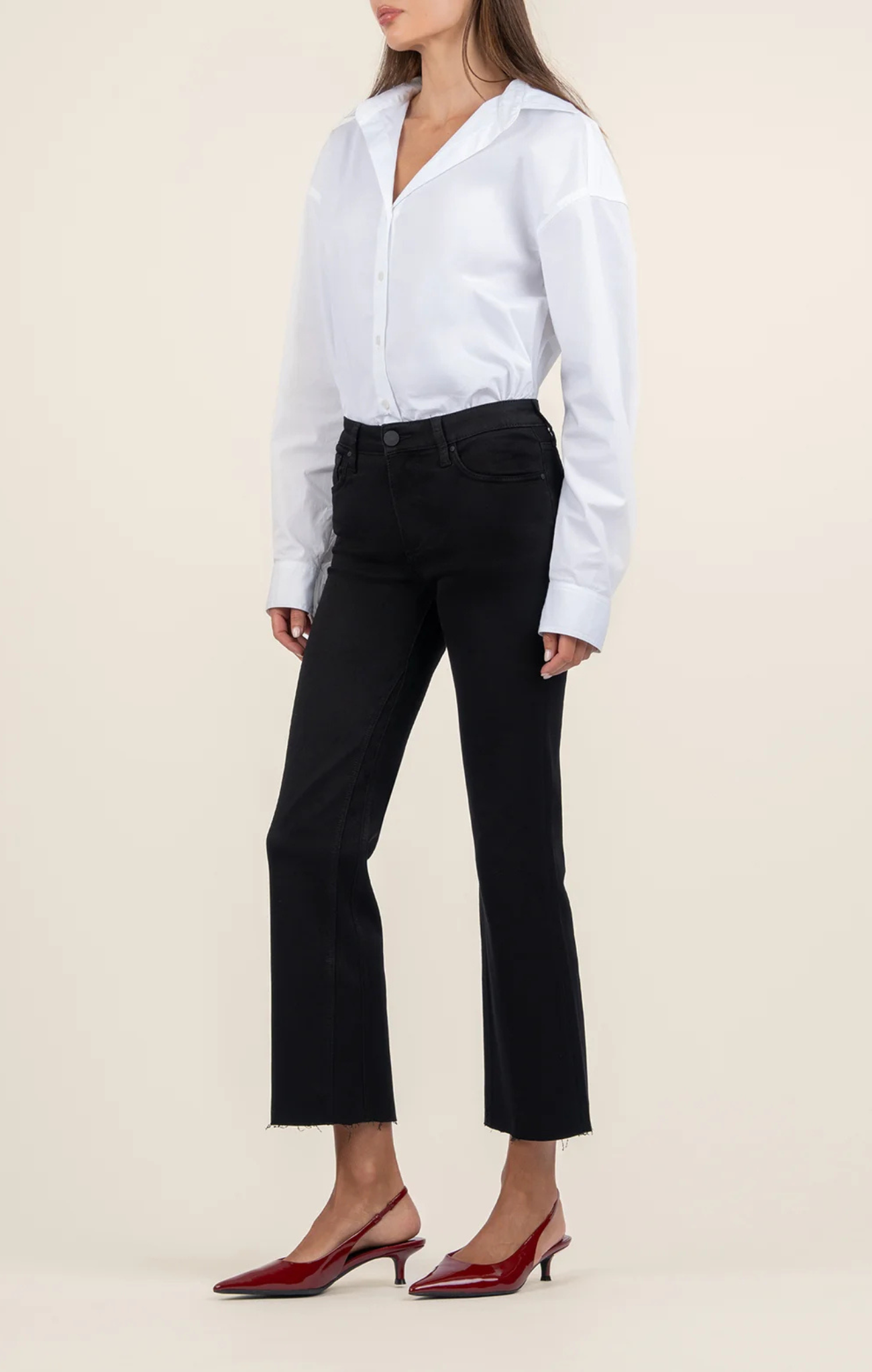 Woman wearing a white shirt and black pants on a beige background