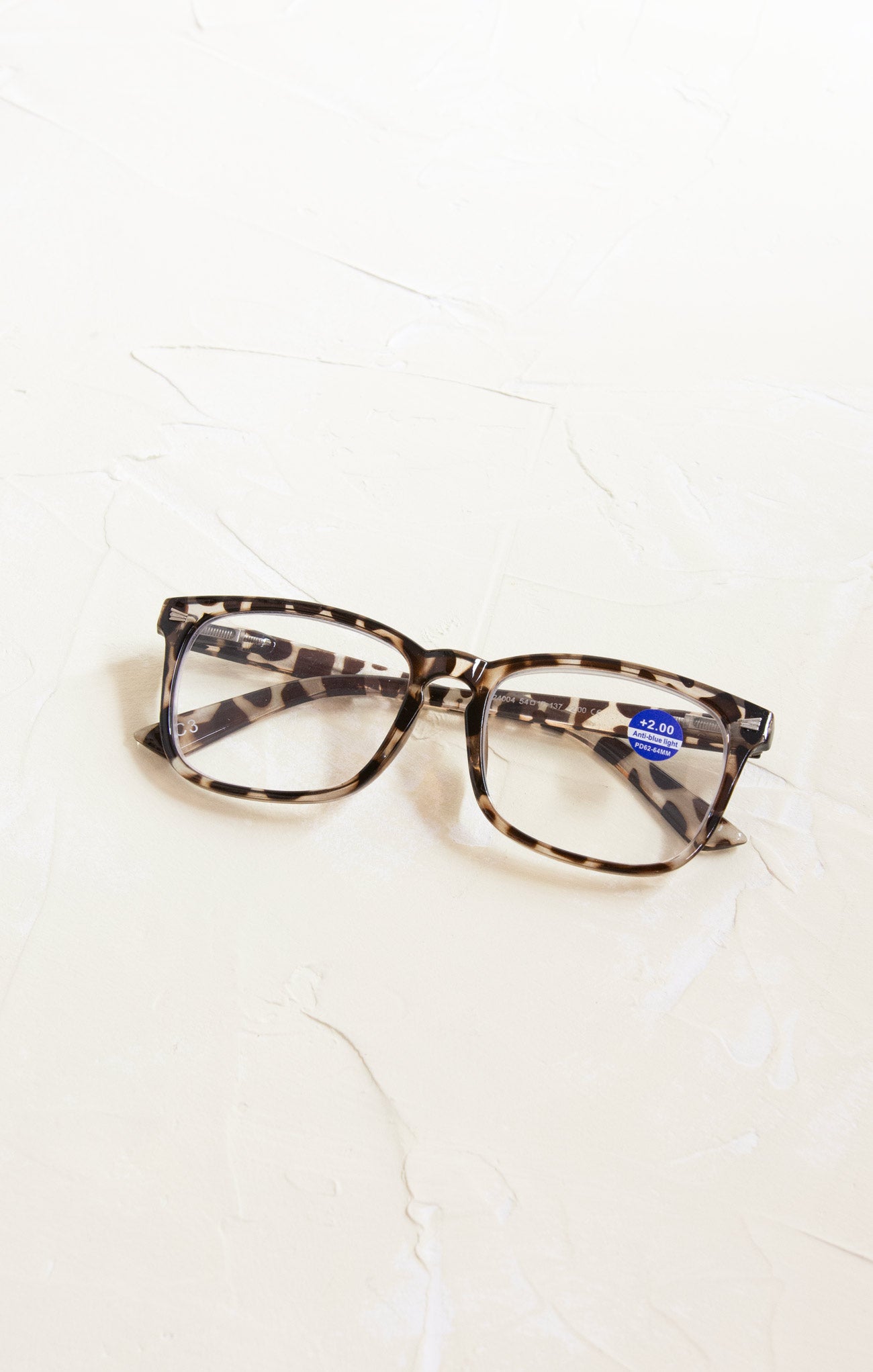 Tortoiseshell glasses with a blue label on a white background