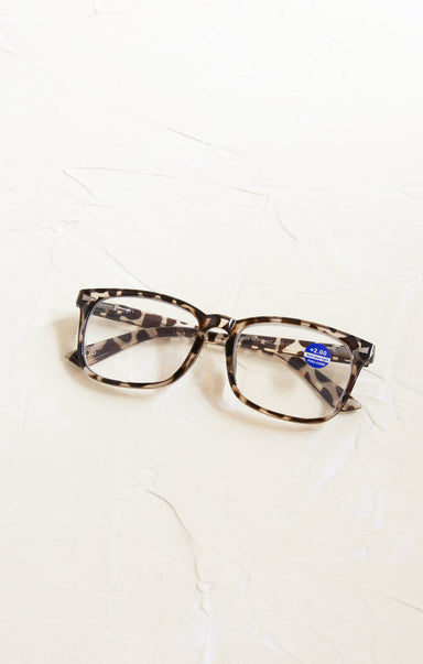 Tortoiseshell glasses with a blue label on a white background