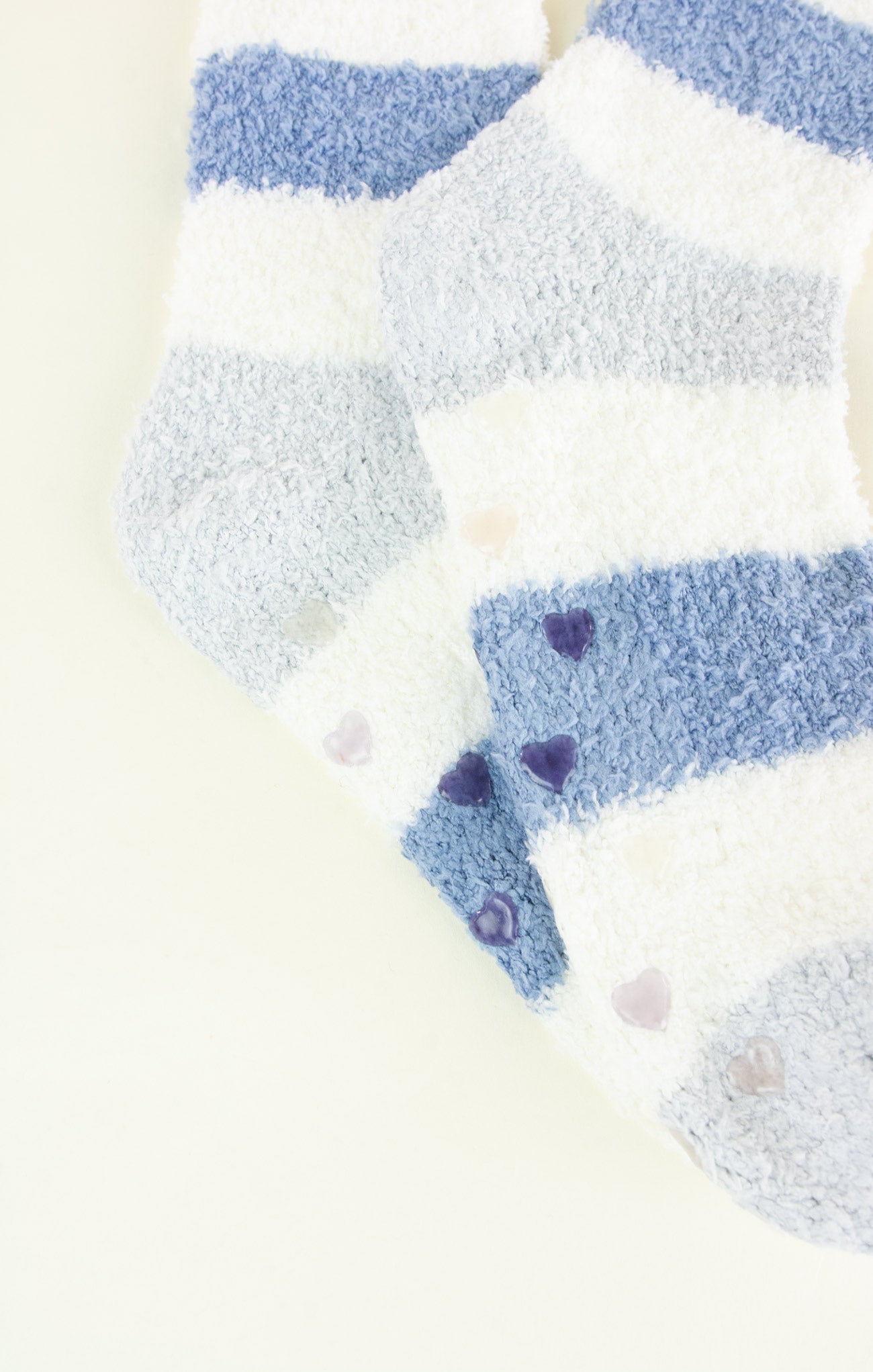 Close-up of blue and white striped socks with heart patterns on a light background