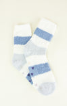 Pair of white socks with blue stripes on a light beige background
