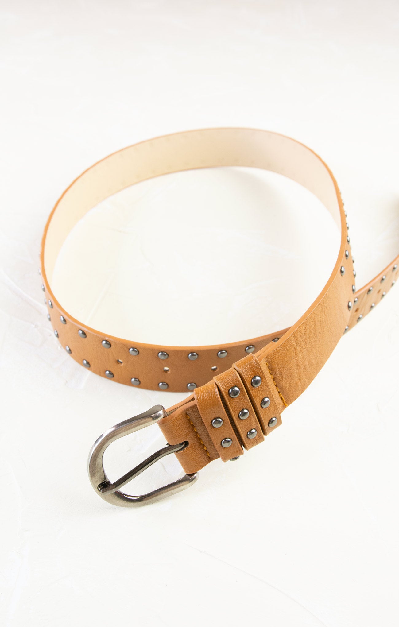 Tan leather belt with studs on a white background