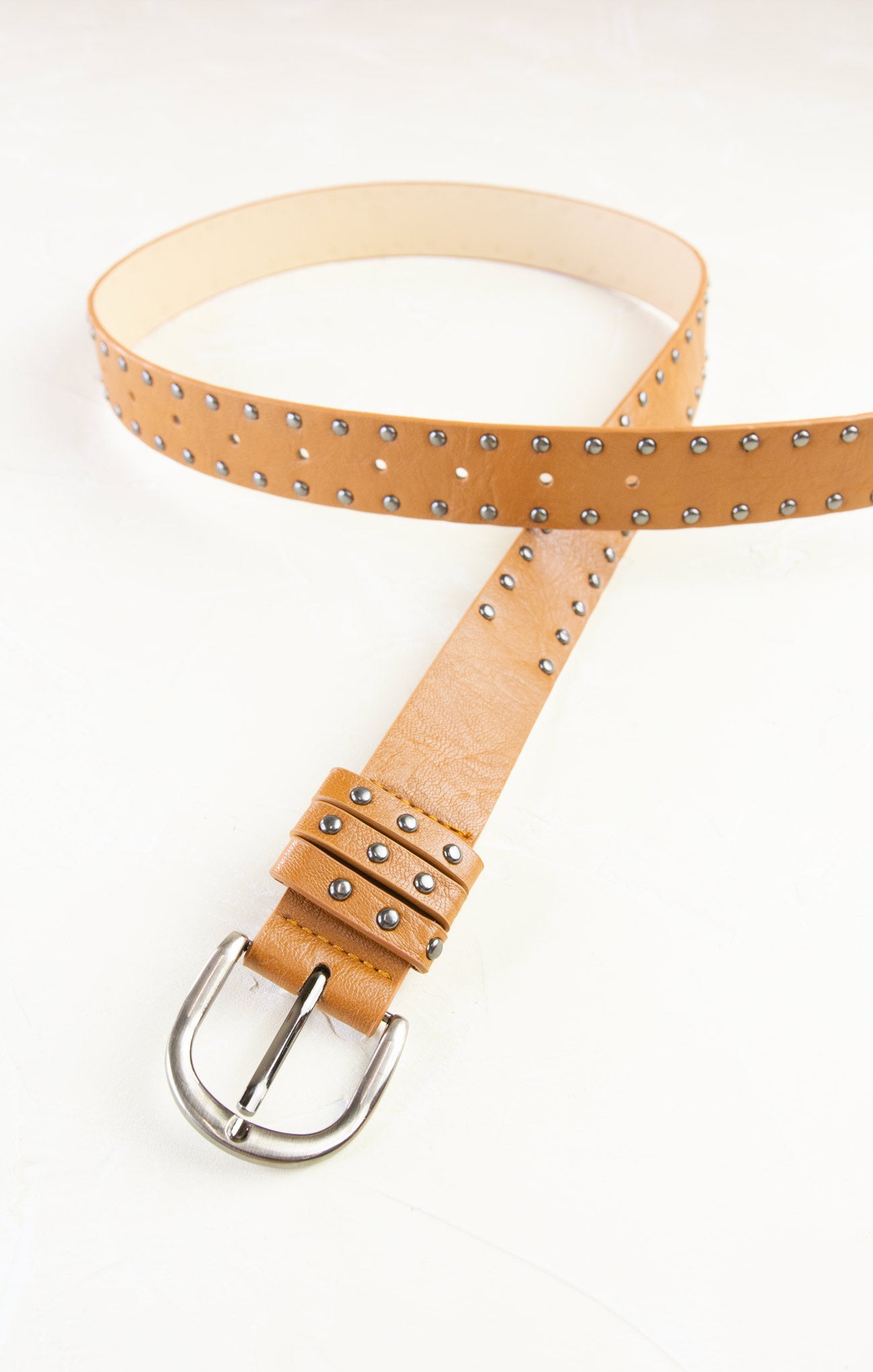 Tan leather belt with silver studs on a white background