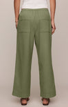 Person wearing green wide-leg pants on a beige background