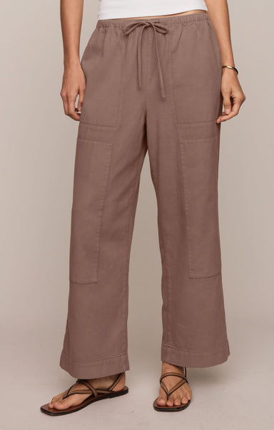 Brown pants worn by a person on a beige background