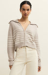 Woman wearing a light gray zip-up sweater with a neutral background