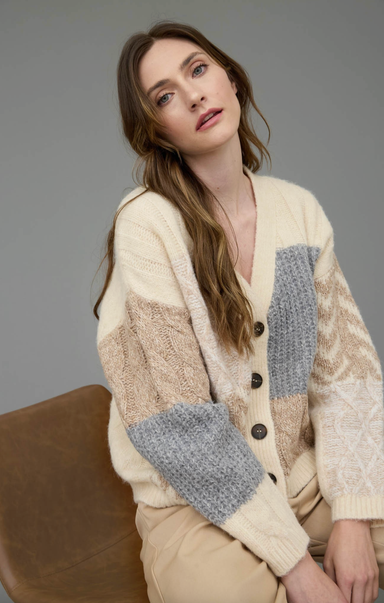Woman wearing a patchwork cardigan with a neutral background