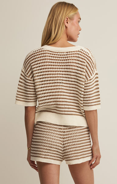 Woman wearing a matching striped outfit with a beige background