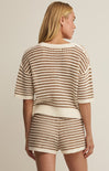 Woman wearing a matching striped outfit with a beige background