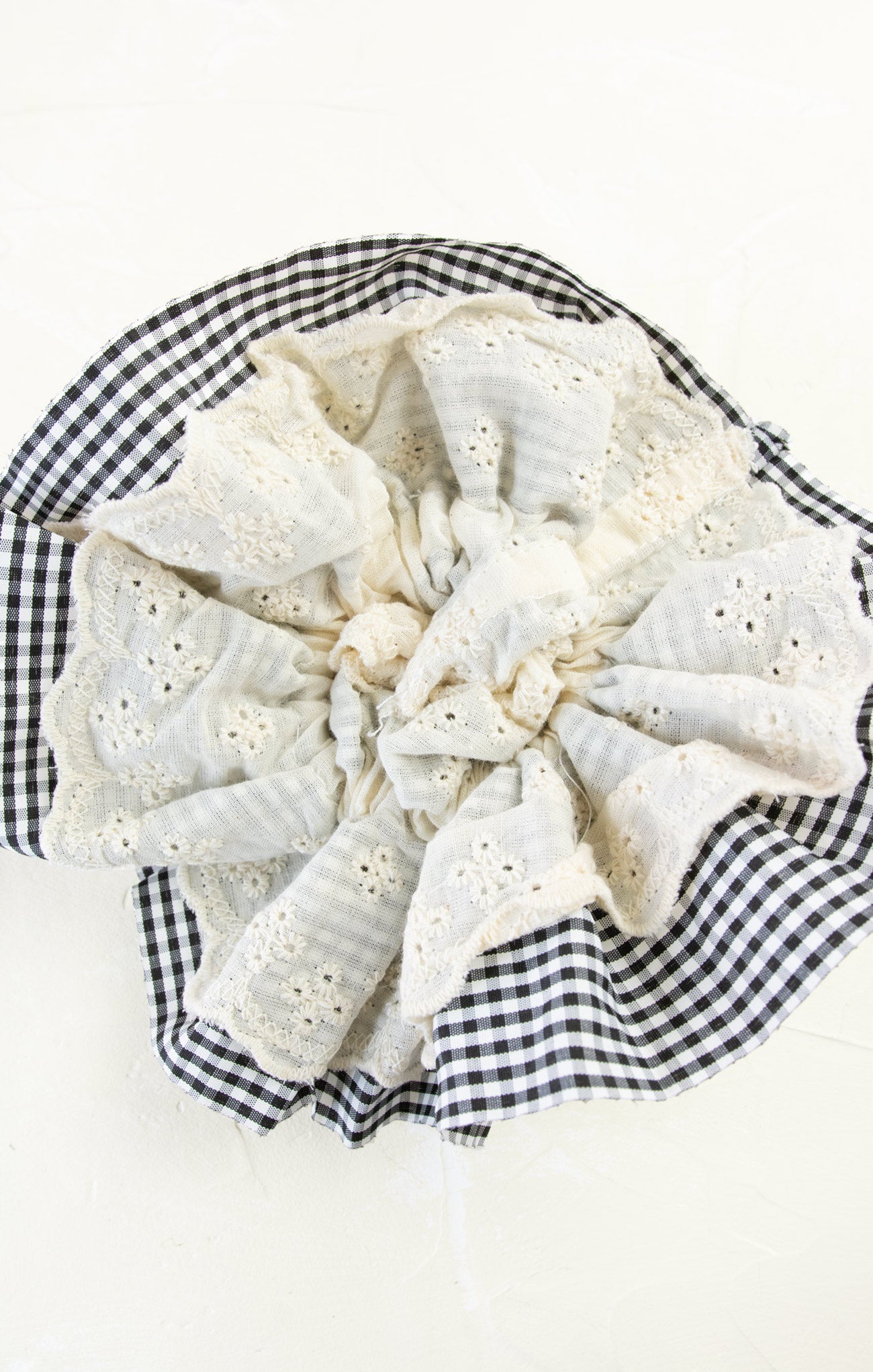 White lace doily on a black and white checkered fabric background