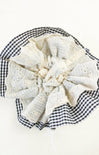 White lace doily on a black and white checkered fabric background