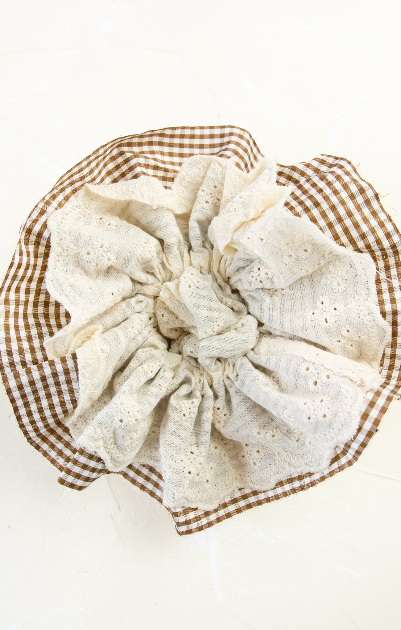 White lace doily on a brown checkered plate with a white background
