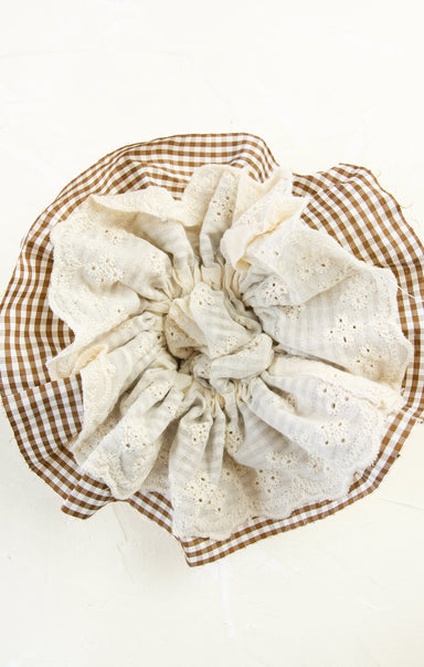 White lace doily on a brown checkered plate with a white background
