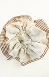 White lace doily on a brown checkered plate with a white background