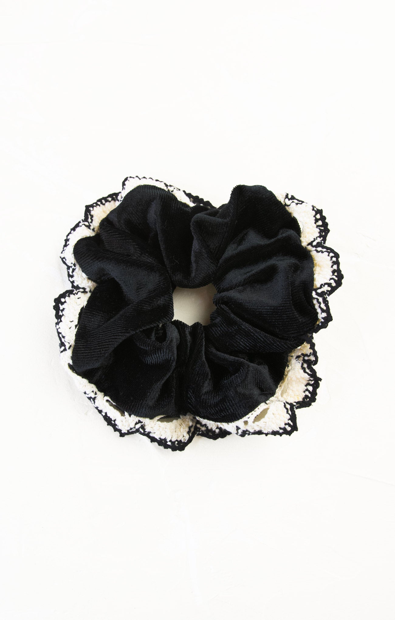Black scrunchie with lace trim on a white background