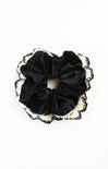 Black scrunchie with lace trim on a white background