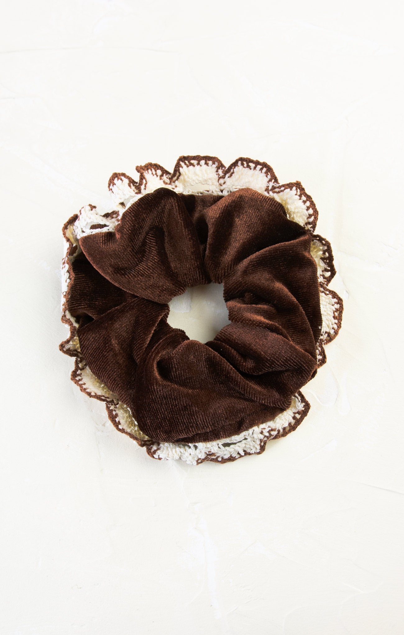 Brown scrunchie with lace trim on a white background