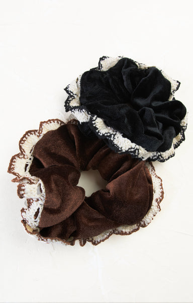 Two scrunchies, one brown and one black, with lace detailing on a white background.