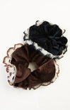 Two scrunchies, one brown and one black, with lace detailing on a white background.