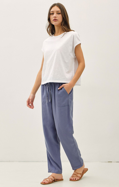 Woman wearing a white t-shirt and blue pants on a white background