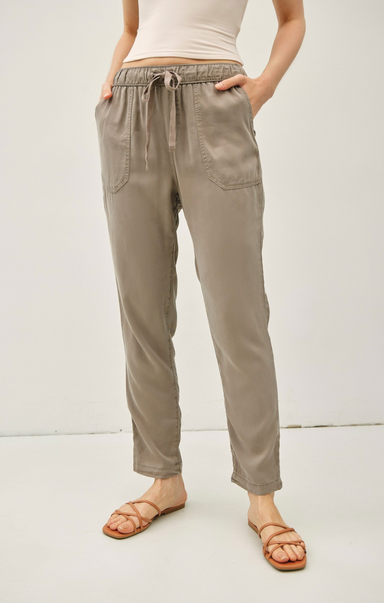 Person wearing beige pants with a white background