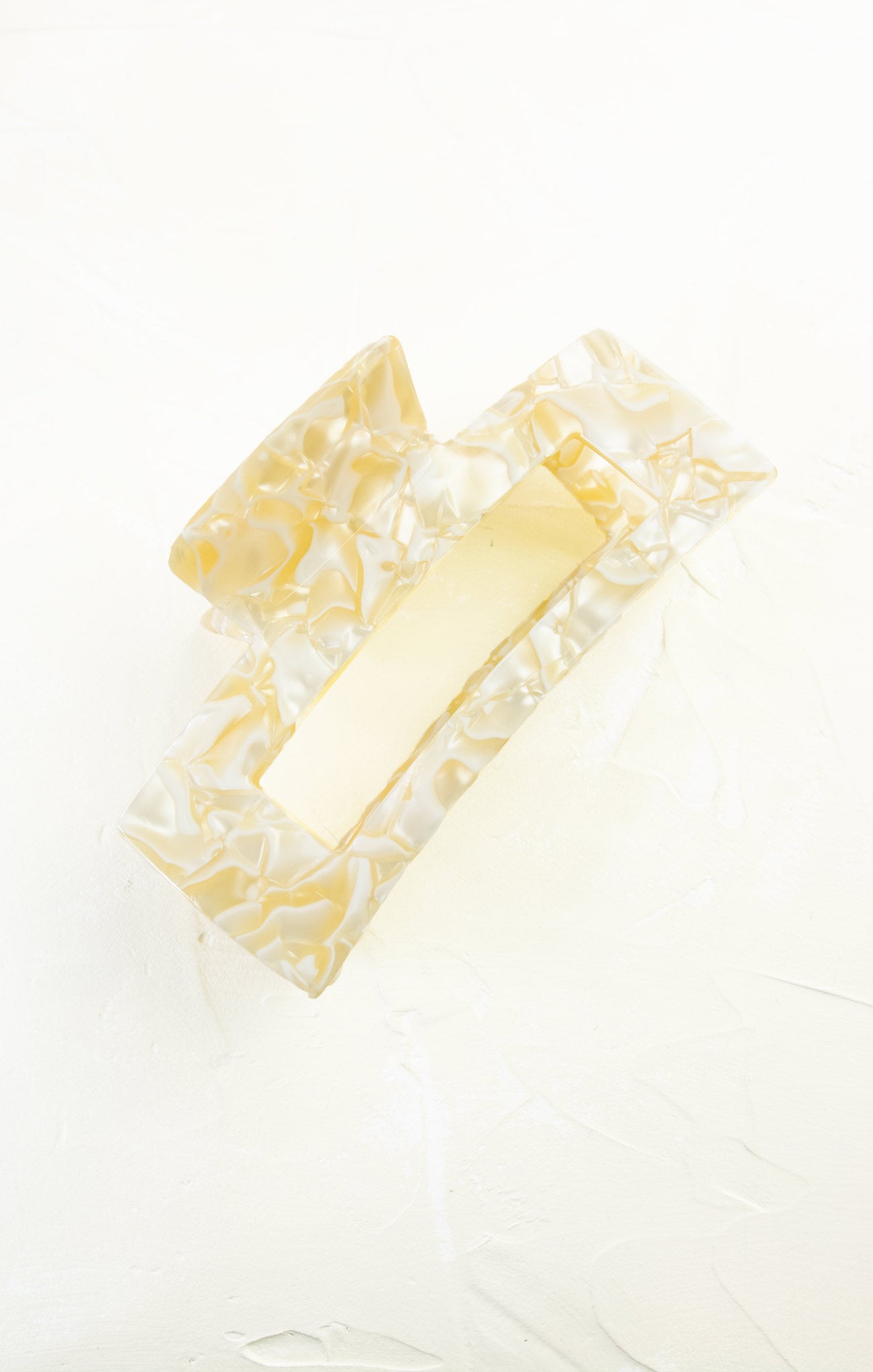 Close-up of a yellow bar of soap with decorative border on a white background